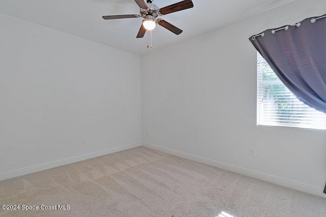 empty room featuring ceiling fan and light colored carpet