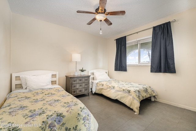 bedroom with ceiling fan and a textured ceiling