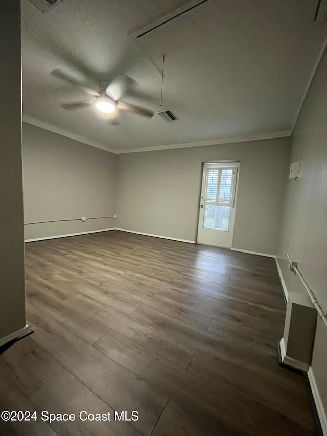 unfurnished room with a textured ceiling, crown molding, ceiling fan, and dark wood-type flooring