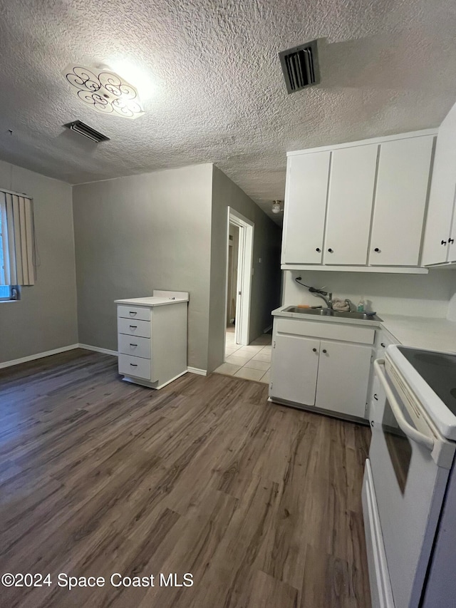 kitchen with dark hardwood / wood-style flooring, white cabinets, a textured ceiling, and sink