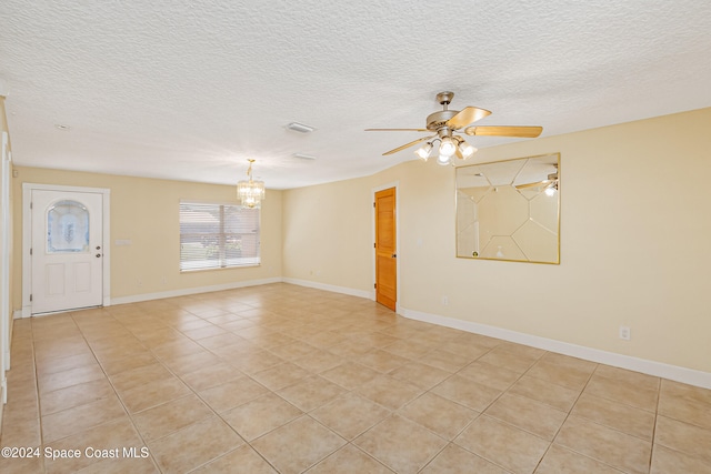 unfurnished room featuring a textured ceiling, light tile patterned floors, and ceiling fan with notable chandelier