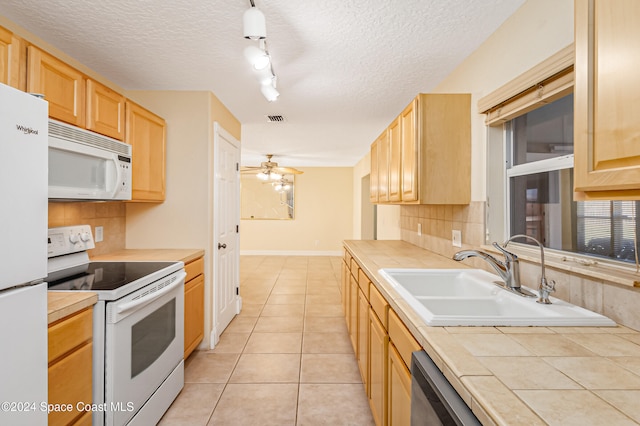 kitchen featuring a textured ceiling, sink, white appliances, and light brown cabinets