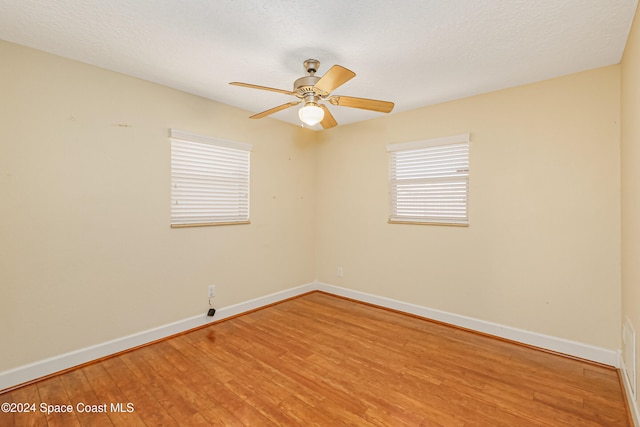 empty room featuring a textured ceiling, hardwood / wood-style flooring, and ceiling fan