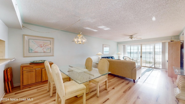 dining room with ceiling fan with notable chandelier, a textured ceiling, and light hardwood / wood-style floors