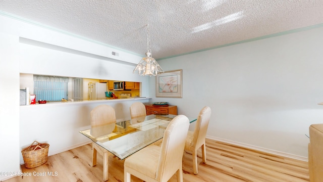 dining room with a textured ceiling and light hardwood / wood-style flooring