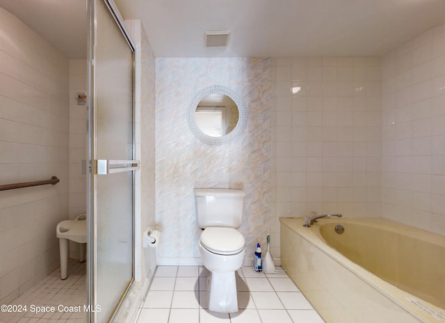 bathroom featuring tile patterned floors, separate shower and tub, tile walls, and toilet