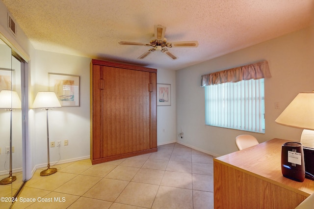 tiled home office with a textured ceiling and ceiling fan