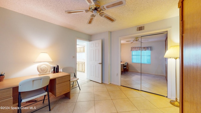 home office with light tile patterned floors, a textured ceiling, and ceiling fan