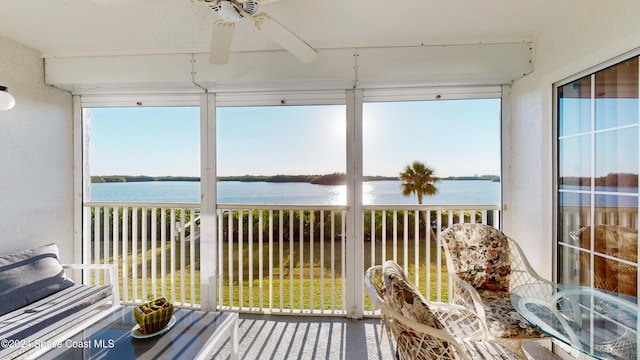 sunroom / solarium featuring ceiling fan and a water view