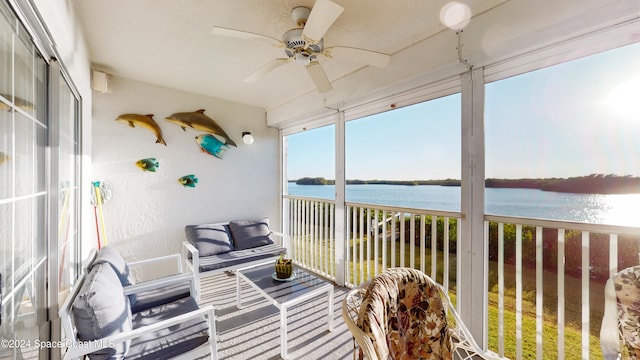 sunroom / solarium featuring ceiling fan and a water view