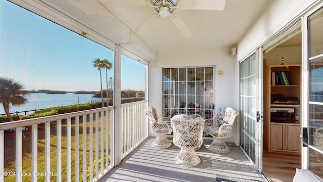 balcony with ceiling fan and a water view