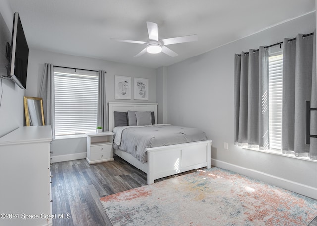 bedroom featuring multiple windows, ceiling fan, and dark wood-type flooring