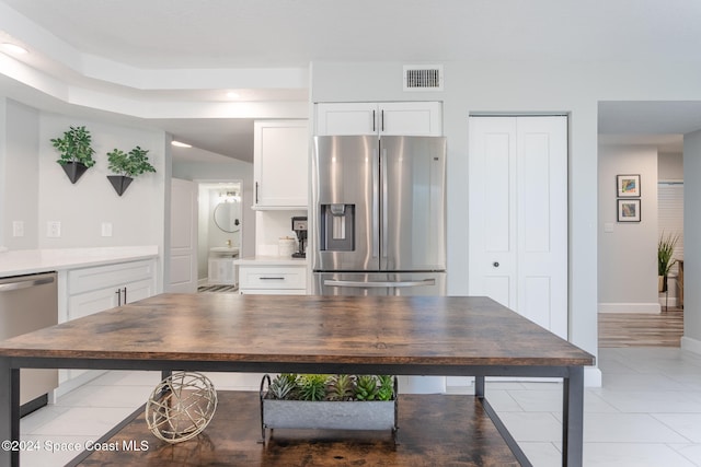 kitchen featuring white cabinets, light tile patterned floors, and appliances with stainless steel finishes