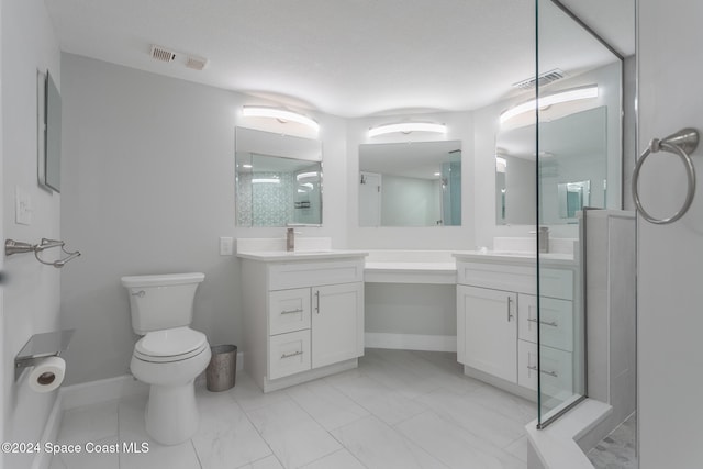 bathroom featuring vanity, a shower with door, and toilet