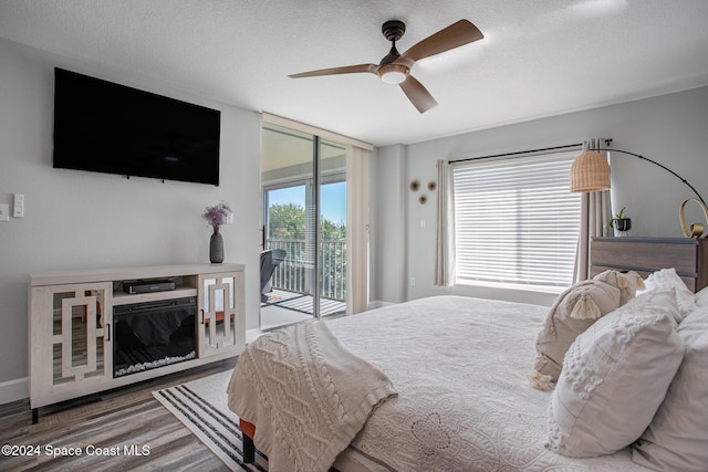 bedroom with hardwood / wood-style floors, ceiling fan, access to outside, and a textured ceiling