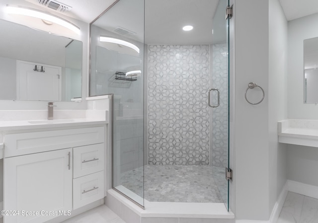 bathroom with vanity and a shower with shower door