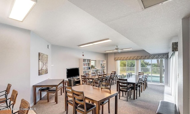 dining space with ceiling fan, carpet floors, and a textured ceiling