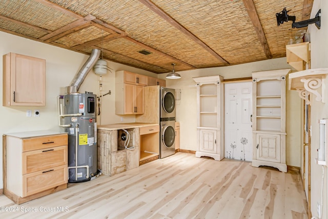 washroom with light wood-type flooring, water heater, and stacked washer / dryer