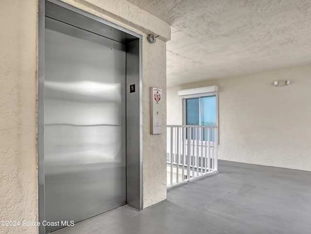 hall with elevator and concrete floors