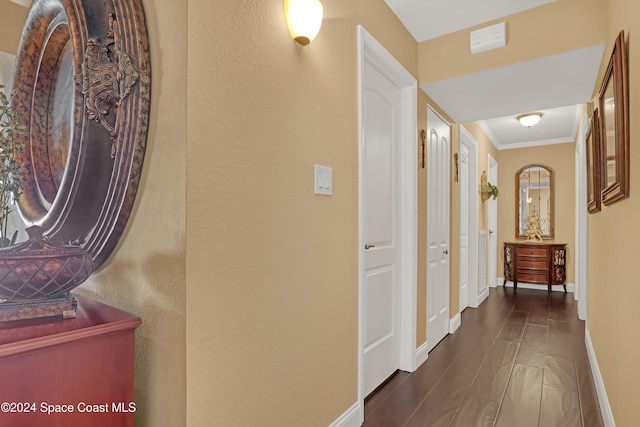 hallway featuring dark hardwood / wood-style flooring and ornamental molding