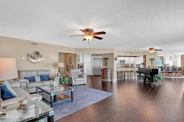 living room with ceiling fan, dark hardwood / wood-style flooring, and a textured ceiling