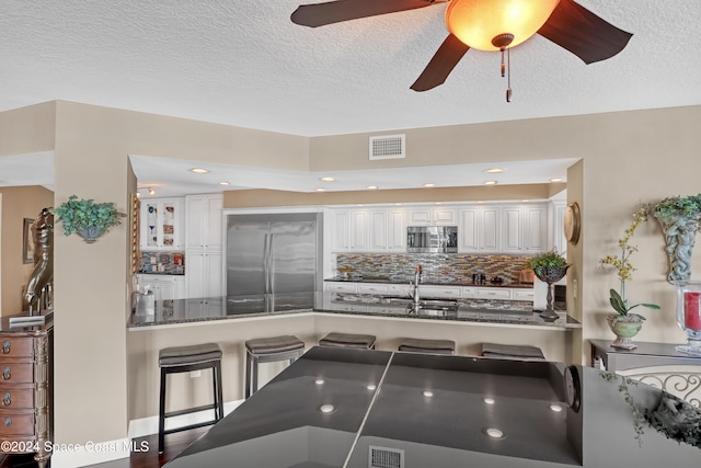 kitchen with white cabinetry, sink, ceiling fan, tasteful backsplash, and appliances with stainless steel finishes