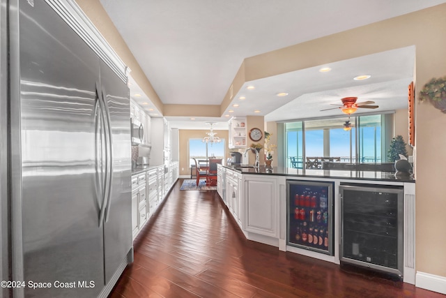 kitchen featuring white cabinets, dark hardwood / wood-style flooring, beverage cooler, and stainless steel appliances