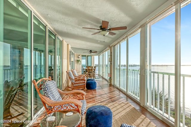 sunroom featuring a wealth of natural light, a water view, and ceiling fan