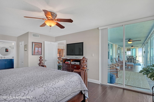 bedroom with access to exterior, ensuite bath, ceiling fan, sink, and dark hardwood / wood-style floors