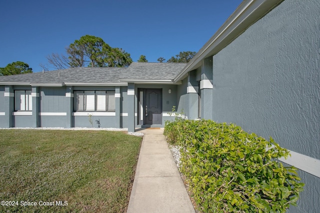 property entrance with a lawn