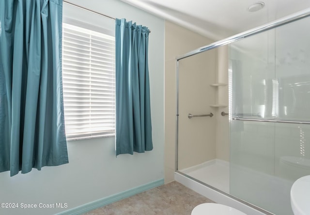 bathroom featuring tile patterned flooring, an enclosed shower, and toilet