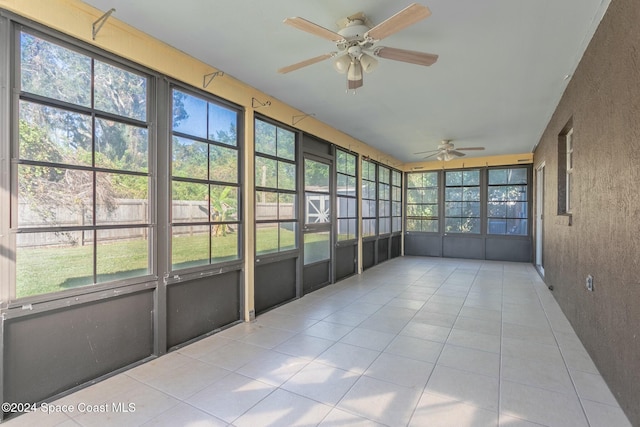 unfurnished sunroom featuring ceiling fan and a healthy amount of sunlight