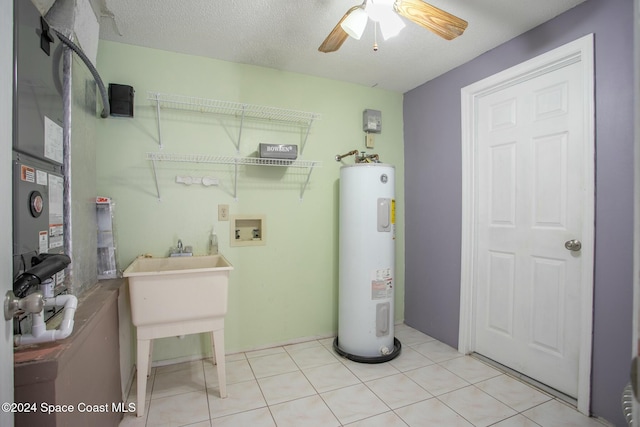 clothes washing area featuring ceiling fan, electric water heater, hookup for a washing machine, a textured ceiling, and light tile patterned flooring