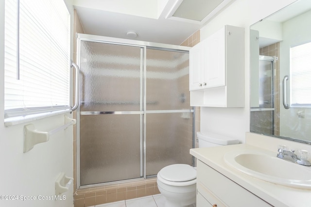 bathroom featuring tile patterned floors, vanity, toilet, and walk in shower