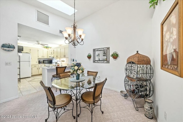 carpeted dining area featuring ceiling fan with notable chandelier and a skylight