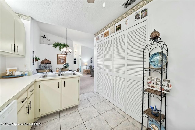 kitchen with dishwasher, an inviting chandelier, cream cabinets, sink, and a textured ceiling