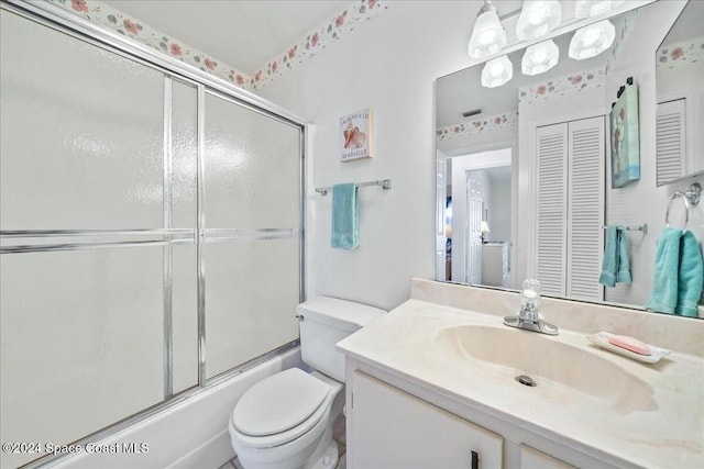 full bathroom with vanity, toilet, and bath / shower combo with glass door