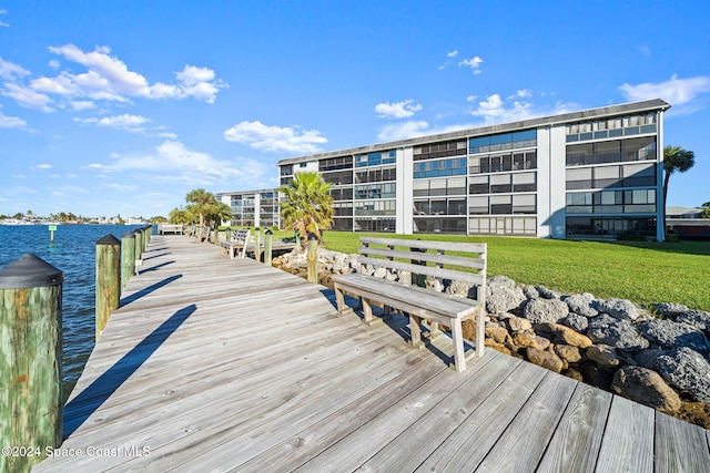 dock area with a yard and a water view