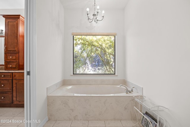 bathroom with tile patterned flooring, tiled bath, and a chandelier