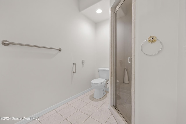 bathroom with tile patterned flooring, a shower with shower door, and toilet