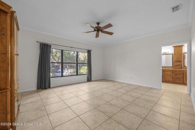 tiled spare room featuring ceiling fan and crown molding