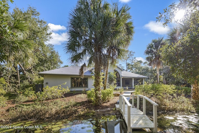 back of property with a water view and central AC unit