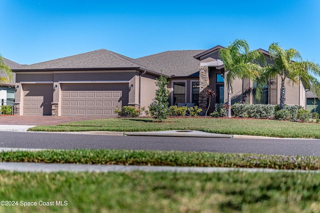 view of front of home with a garage and a front lawn