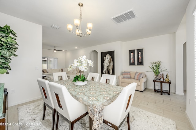 dining room with ceiling fan with notable chandelier