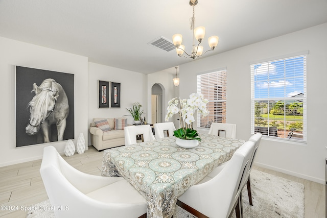 dining space featuring a wealth of natural light and an inviting chandelier