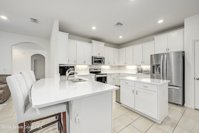 kitchen featuring appliances with stainless steel finishes, sink, a center island with sink, and white cabinets