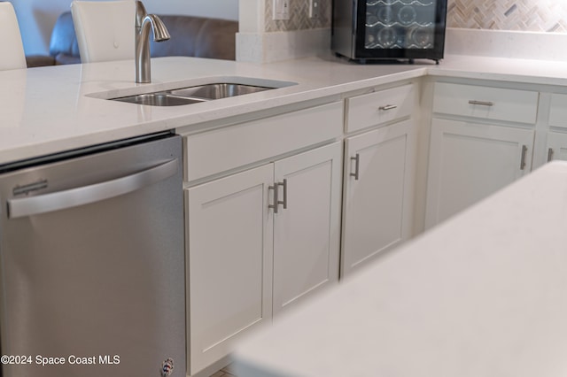 kitchen with white cabinetry, dishwasher, and sink