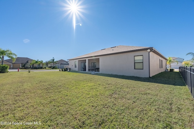 rear view of property featuring a lawn