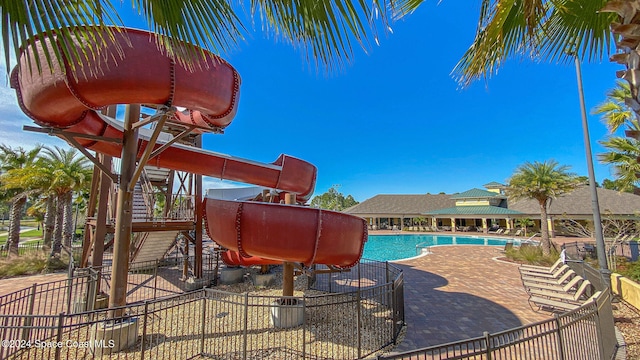 view of swimming pool featuring a playground and a water slide