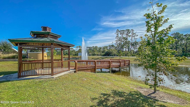 view of dock with a water view, a yard, and a gazebo